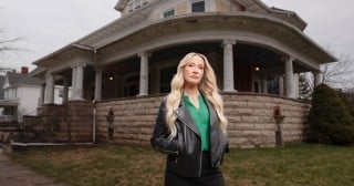 Host Anna Camp stands in front of Bihl Manor for HGTV's A Very Haunted Renovation