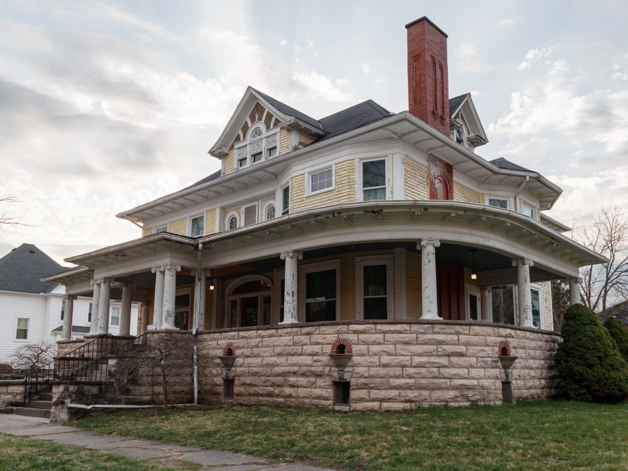 Bihl Manor in Fremont, Ohio, a yellow Victorian mansion with a wraparound porch, before the HGTV renovation