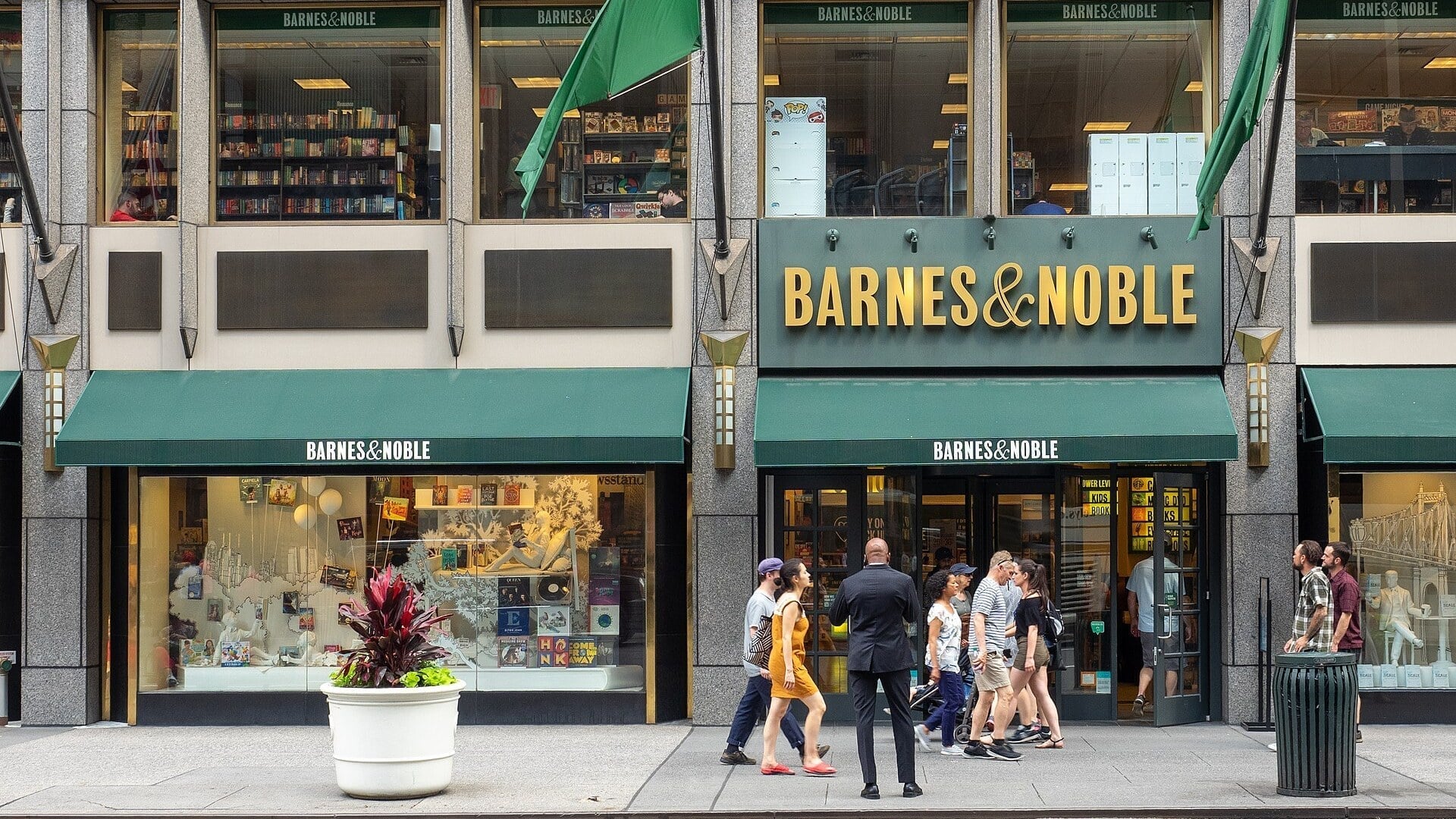 A Barnes & Noble storefront on Fifth Avenue in New York, with shoppers walking past the entrance