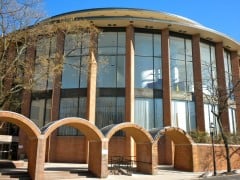 The rounded brick and glass front of the Bucks County Courthouse in Doylestown, Pennsylvania, behind a row of brick arches