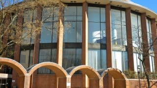 The rounded brick and glass front of the Bucks County Courthouse in Doylestown, Pennsylvania, behind a row of brick arches