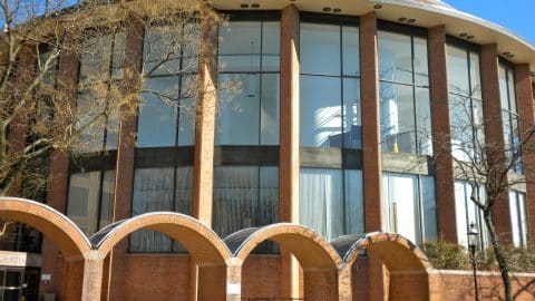 The rounded brick and glass front of the Bucks County Courthouse in Doylestown, Pennsylvania, behind a row of brick arches