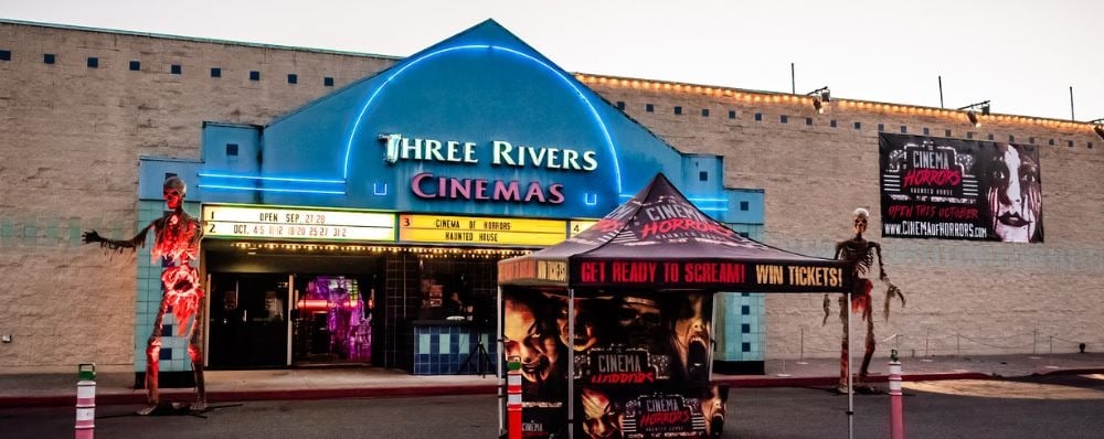 The old Three Rivers Cinemas building in Kelso, Washington, dressed with Cinema of Horrors signs and giant skeleton figures