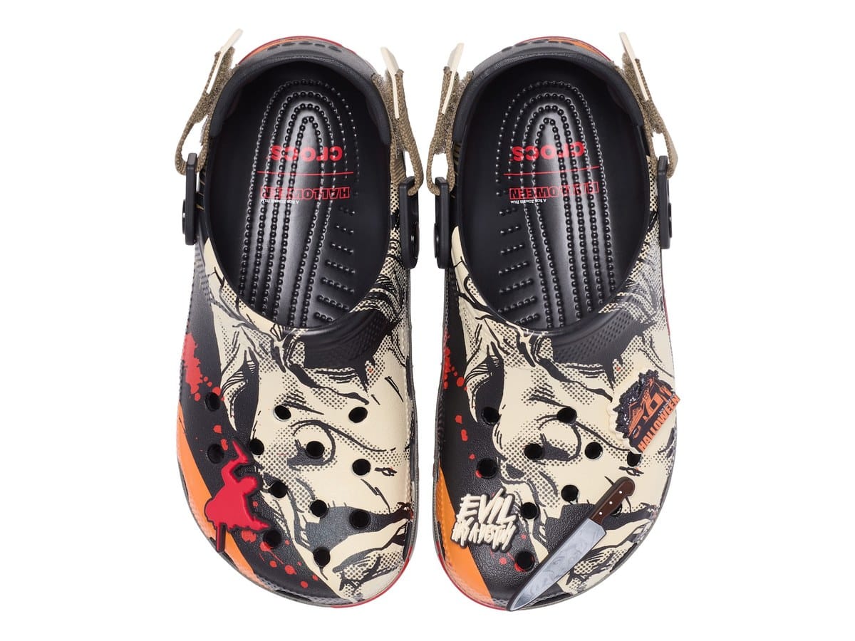 Top view of Crocs' Halloween Michael Myers Classic Clogs with a comic-style Michael Myers face, a knife charm, a Halloween house charm and an Evil Has a Destiny charm
