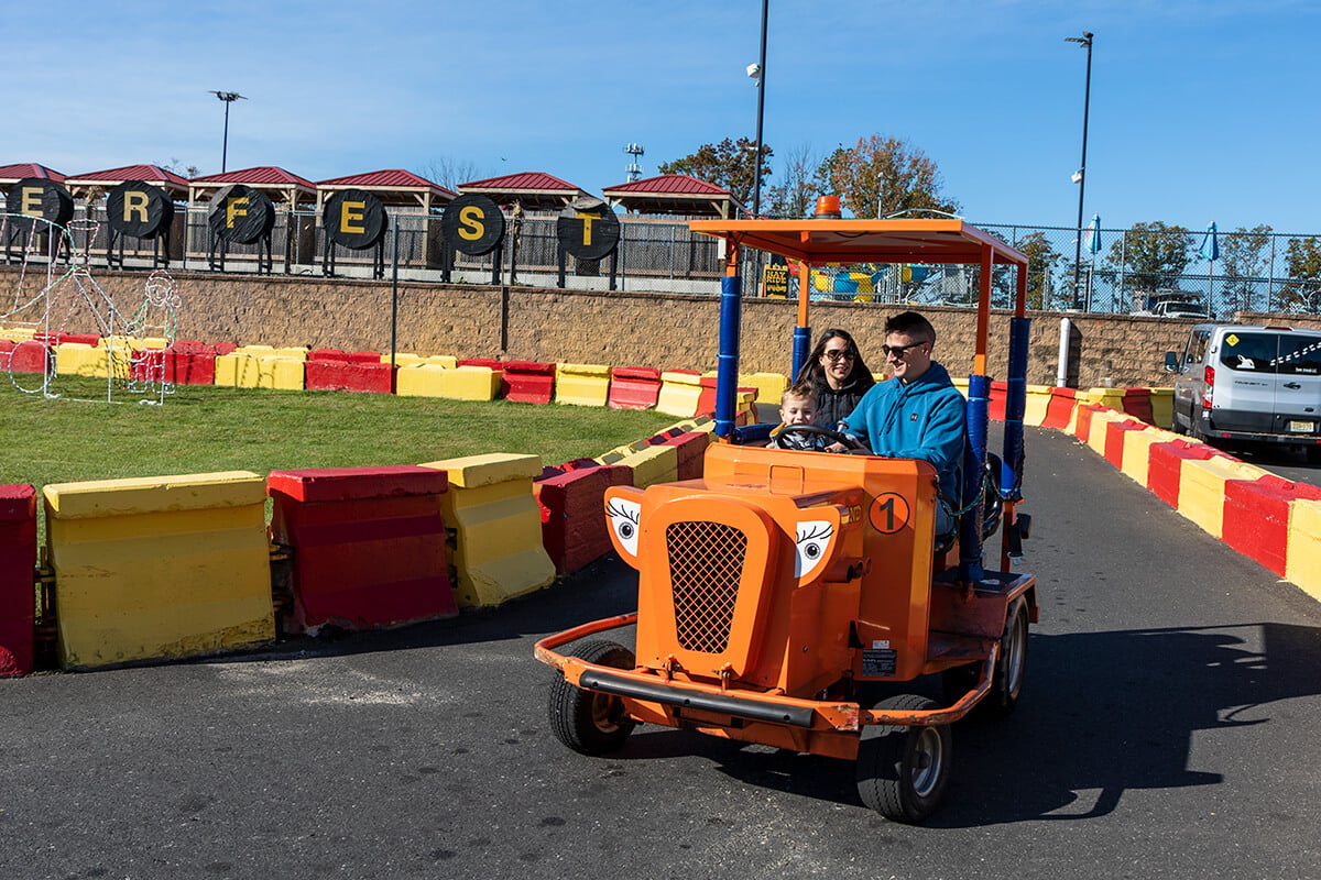 A family rides a tractor past the DIGGERFEST sign at Diggerland USA