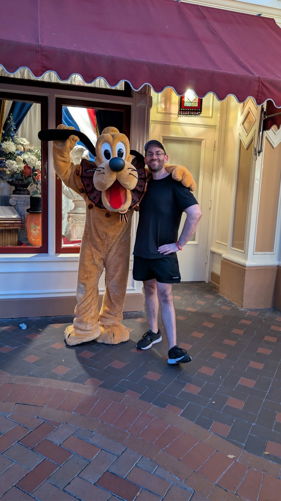 Philip Hernandez with Pluto in his Halloween outfit on Main Street, U.S.A.