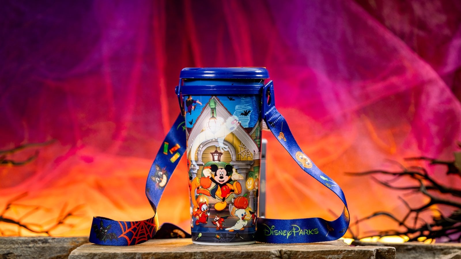 Disneyland Halloween travel tumbler with Mickey and friends in costume and a purple candy-print strap