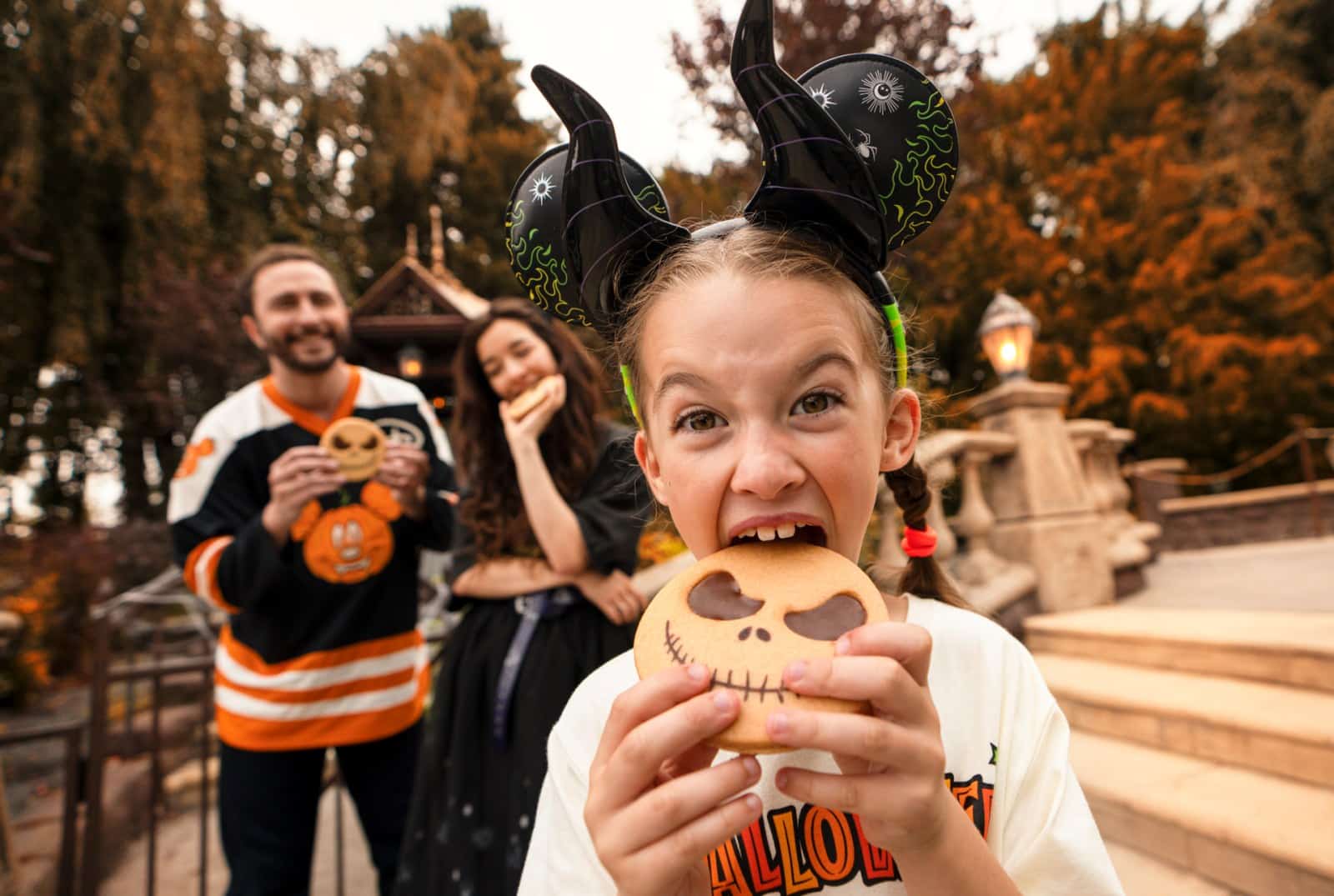 A guest eating a Jack Skellington cookie at Disneyland Paris during Halloween
