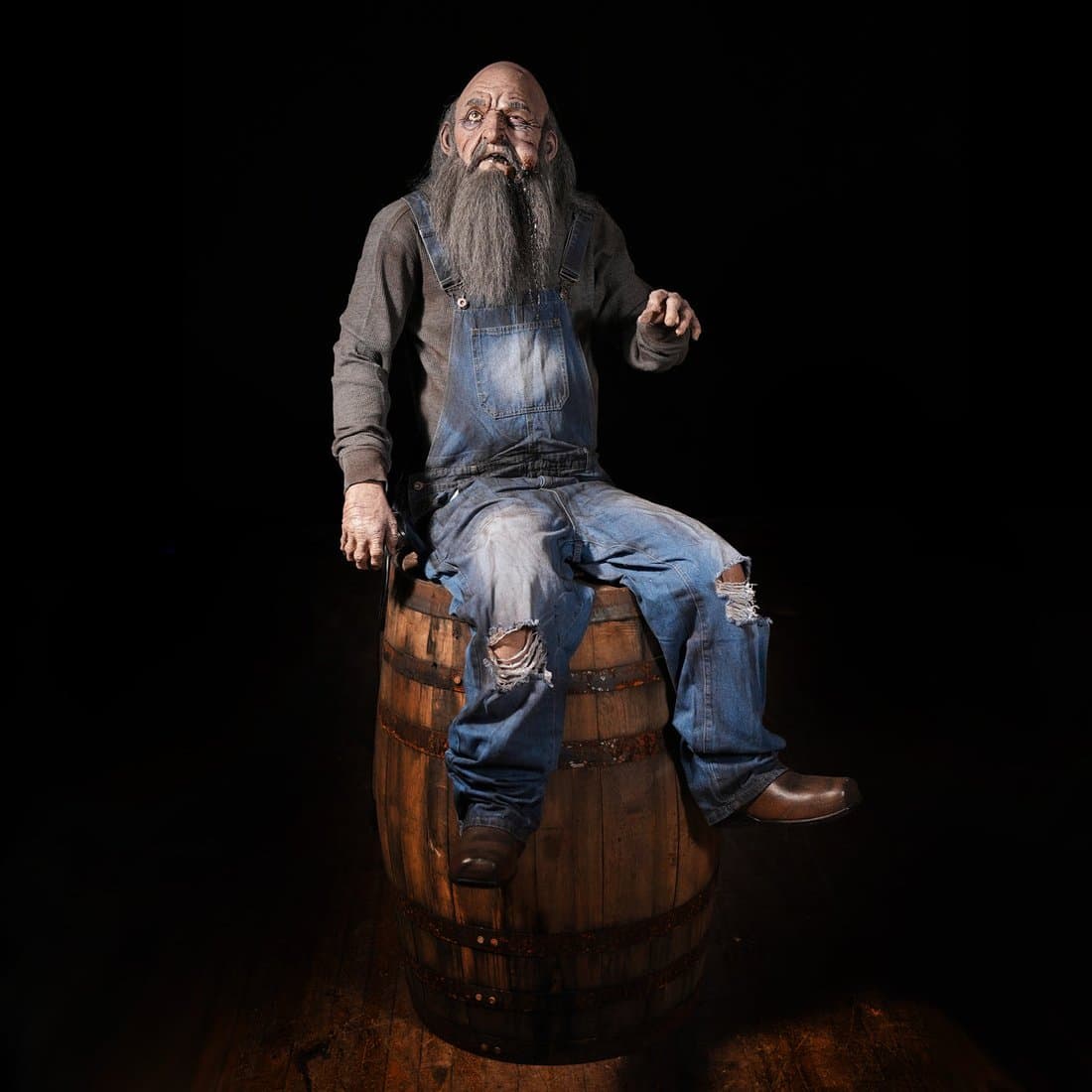 Distortions Unlimited Grumpy Grandpa animatronic seated on a barrel