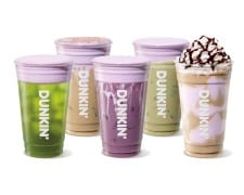 Five iced and frozen Dunkin drinks in clear cups, green, tan, purple, and pale green, topped with purple foam, one with whipped cream and chocolate drizzle