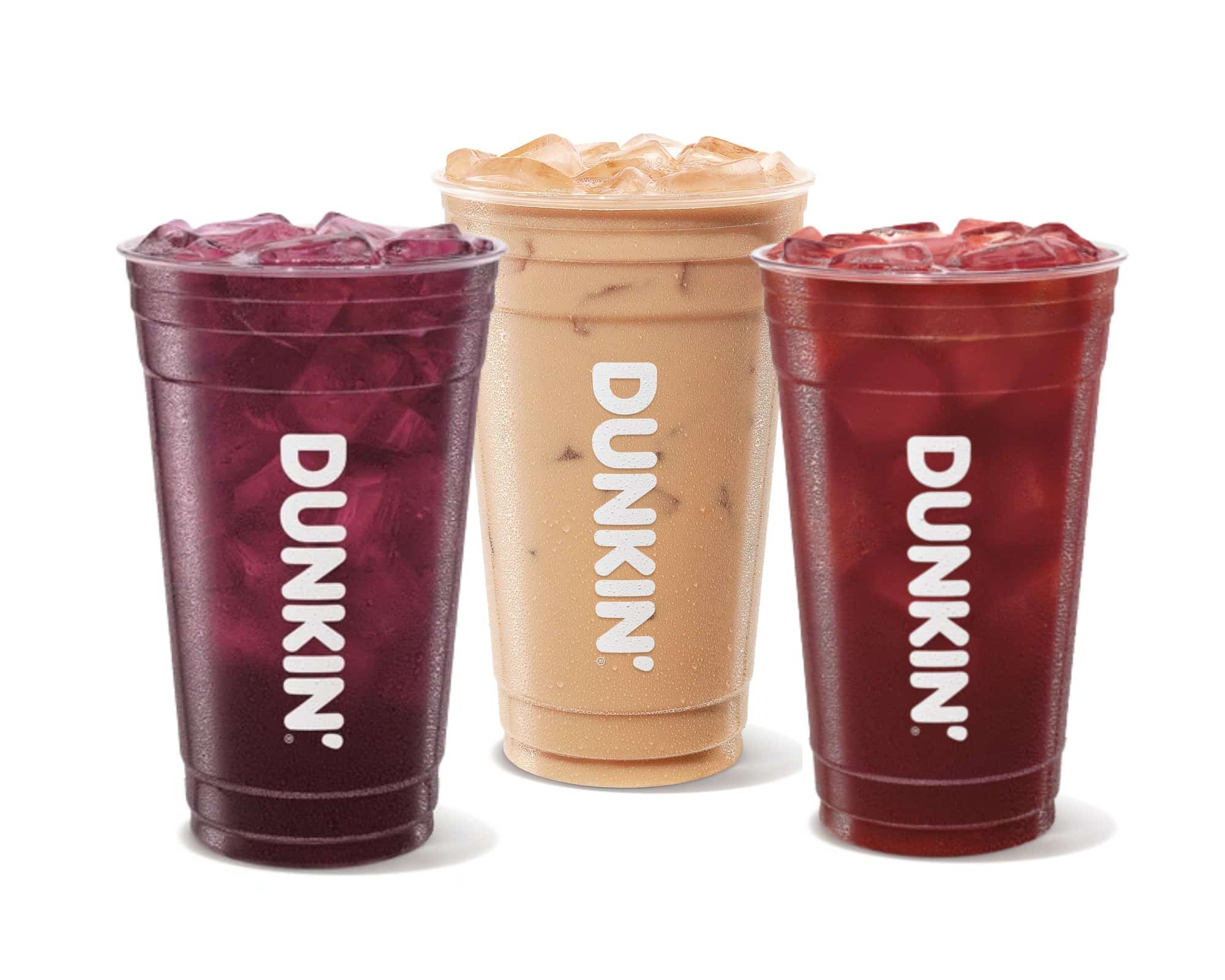 A dark purple iced drink, a tan iced coffee, and a red iced drink in clear Dunkin cups