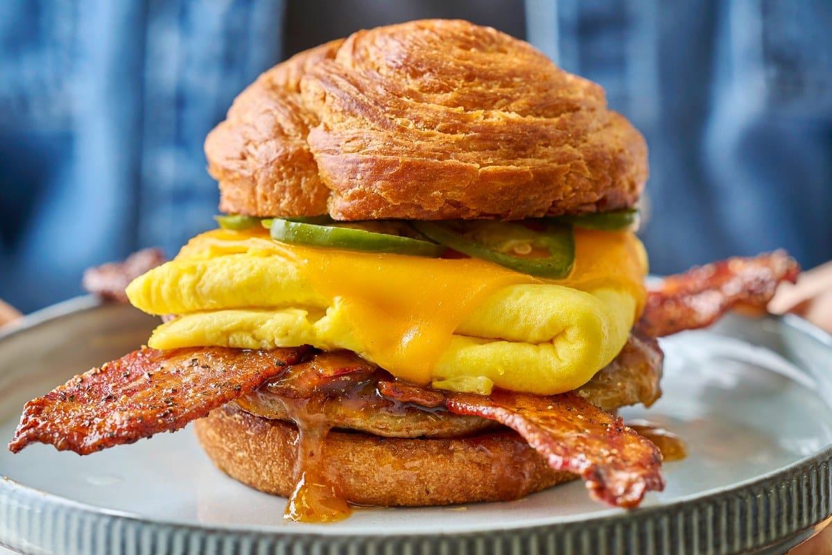 First Watch Maple Bacon Croissant Sandwich with Million Dollar Bacon, egg, cheddar, and pickled jalapenos on a croissant