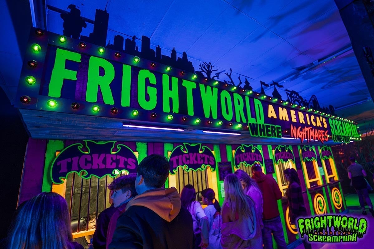 The neon Frightworld ticket-booth marquee with guests lined up at the Buffalo screampark