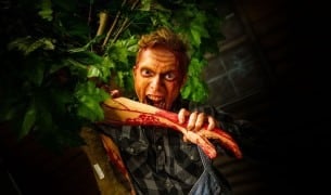 A bloodied scareactor lunges at guests during Fright Fest at Six Flags Great Adventure