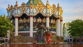 A pumpkin-headed figure and skeletons in a blood-red fountain before the carousel at Six Flags Great America Fright Fest