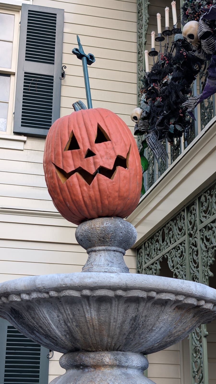 A jack-o'-lantern on the fountain outside Haunted Mansion Holiday at Disneyland