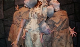 Pale, silent-screaming performers in tattered gowns bound behind barbed wire in Urban Death at Zombie Joe's Underground Theatre in North Hollywood.