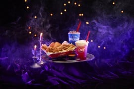 Dairy Queen's Spellbound Series Halloween menu on a silver tray: the purple Enchanted OREO Blizzard, the Bubble Brew Sparkler, and a Chicken Strip Basket with Ghost Pepper Sauce