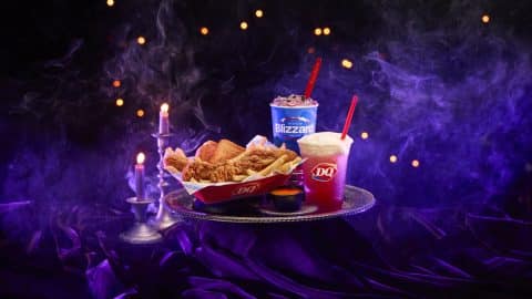 Dairy Queen's Spellbound Series Halloween menu on a silver tray: the purple Enchanted OREO Blizzard, the Bubble Brew Sparkler, and a Chicken Strip Basket with Ghost Pepper Sauce
