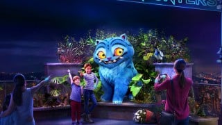 A rendering of guests posing with a giant Derpy Tiger and Sussie Bird in a rooftop garden at KPop Demon Hunters: The Immersive Experience