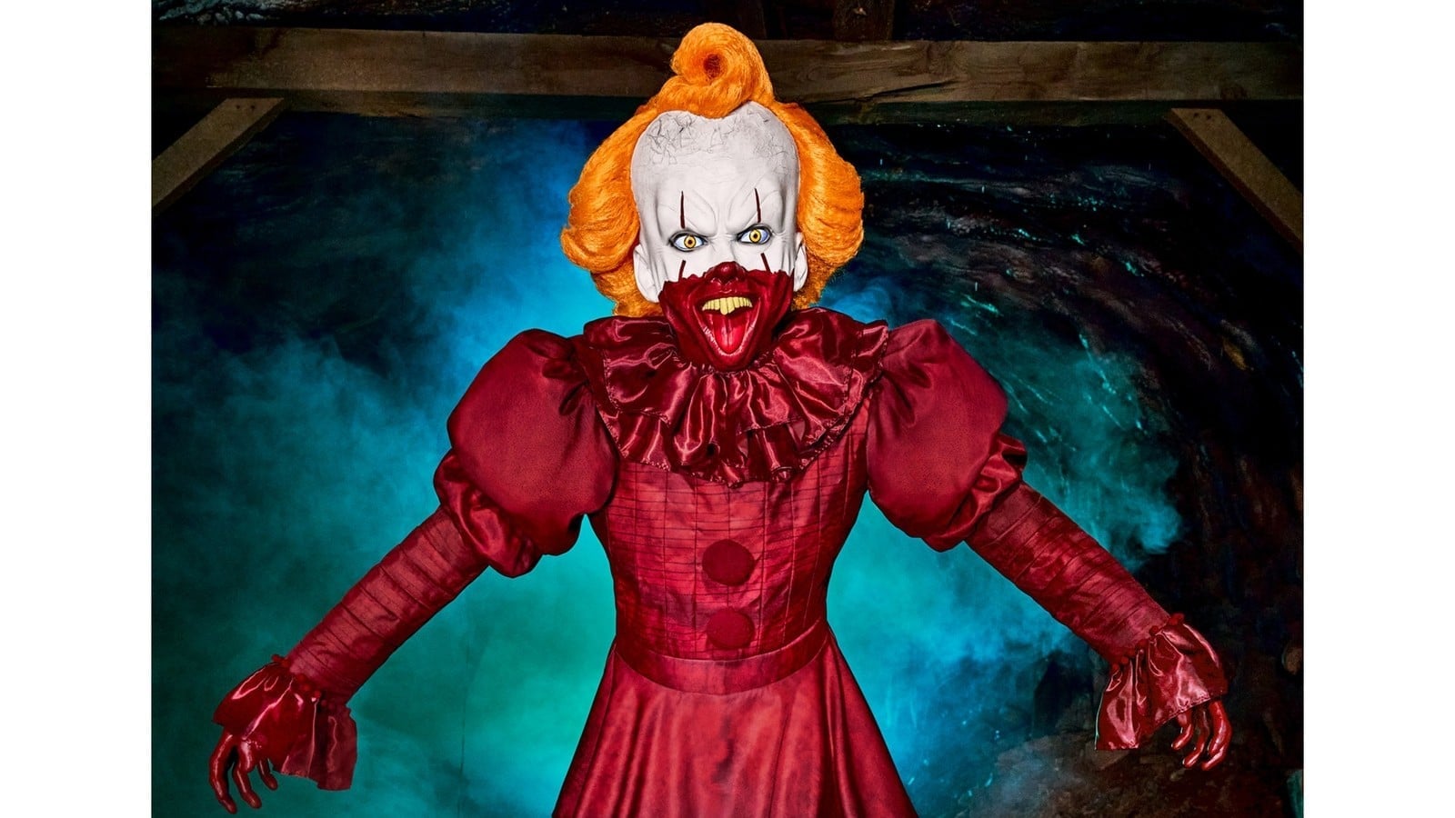 A 6-foot-10 Pennywise animatronic from Spirit Halloween, grinning with arms open in a sewer-themed display
