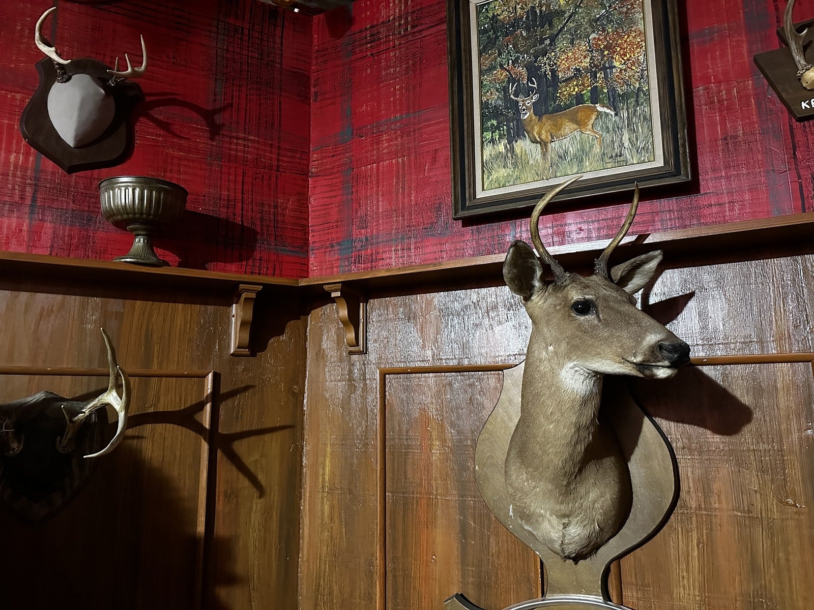 A 1930s hunting lodge room with mounted antlers and a deer head in the Estate of Evil