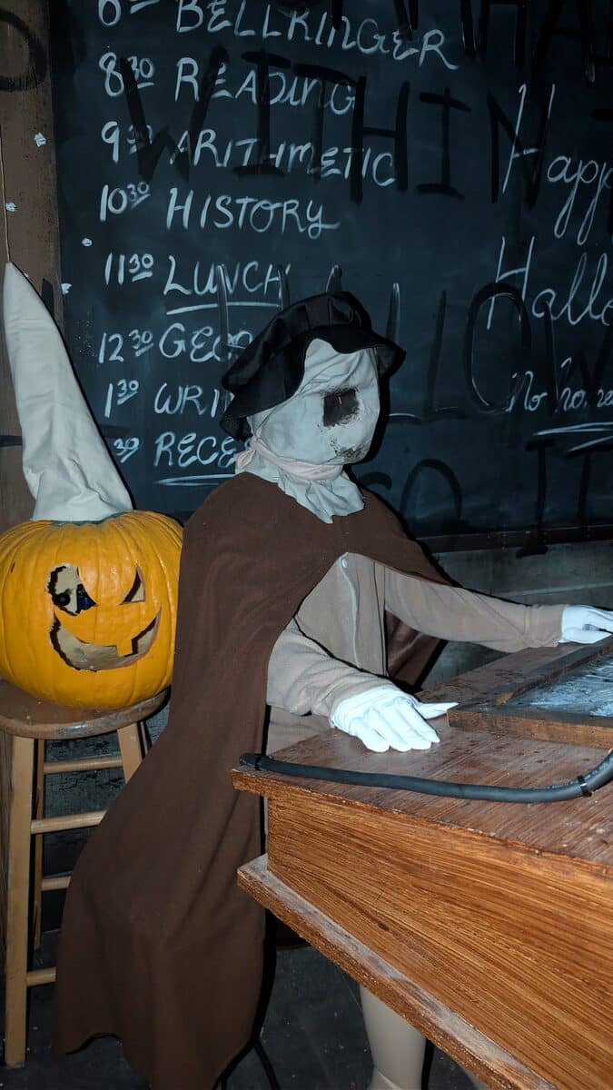 Creepy schoolhouse scene with a pumpkin-headed pupil