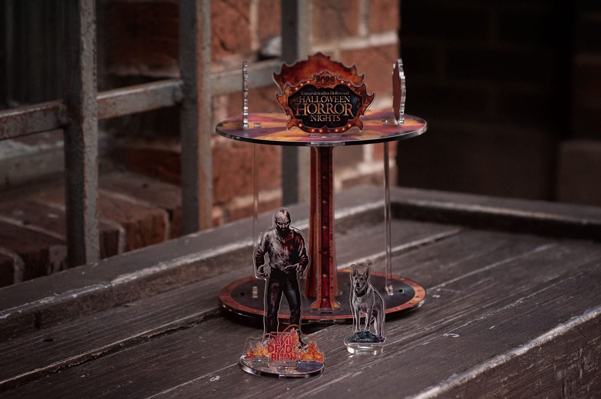 Evil Dead Burn HHN 2026 limited-release merchandise: T-shirt, hat, and infernal carnival acrylic figure