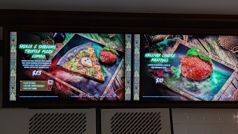 Two lit menu screens picturing a pizza slice with a meatball and a single meatball, each with a printed name and price