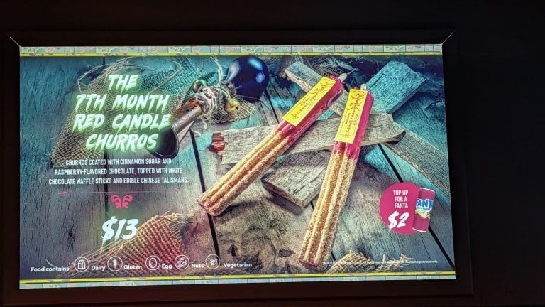 A lit menu screen picturing two long red churros in wrappers with a printed name and price