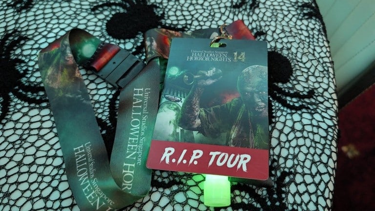 A lanyard and a card with a zombie illustration on a lace tablecloth