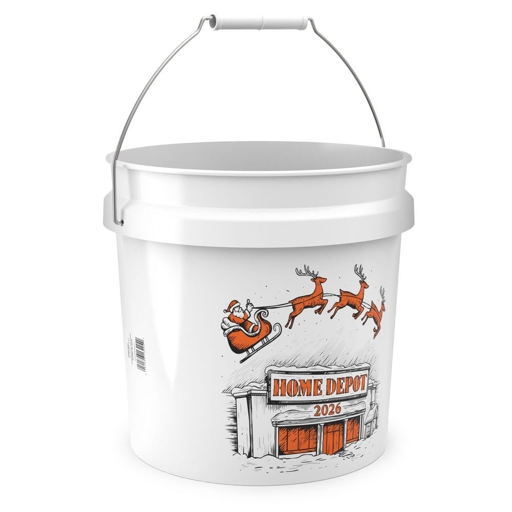 A white bucket with a metal handle, printed with Santa's sleigh and three reindeer flying over a snow-covered store