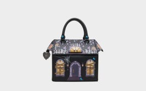 Betsey Johnson haunted house purse: a crossbody bag shaped like a spooky mansion with a tiled roof, glowing windows, and spider webs