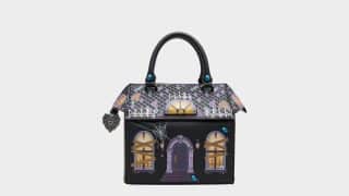 Betsey Johnson haunted house purse: a crossbody bag shaped like a spooky mansion with a tiled roof, glowing windows, and spider webs