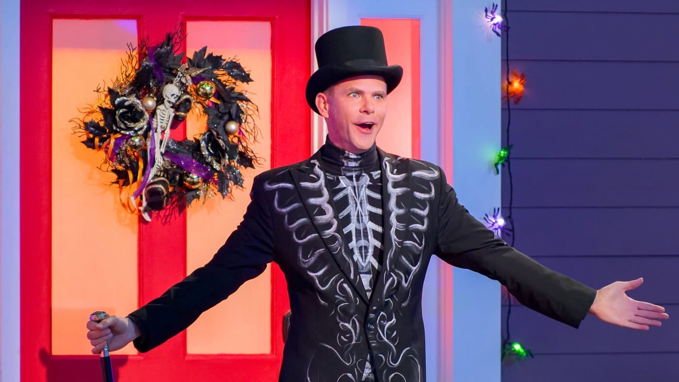 Mikey Day in a skeleton-print suit and top hat on the Is It Cake? Halloween set