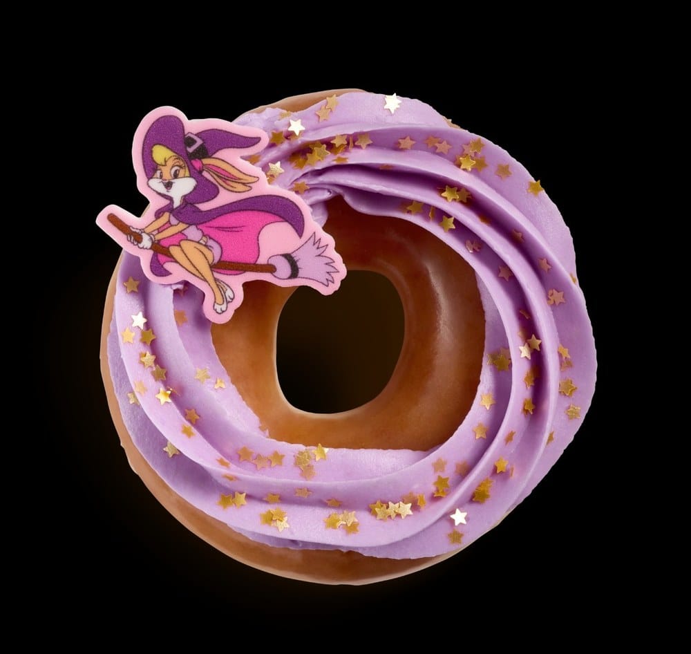 A glazed doughnut with a purple icing swirl, gold star sprinkles, and a sugar piece of Lola Bunny as a witch on a broom