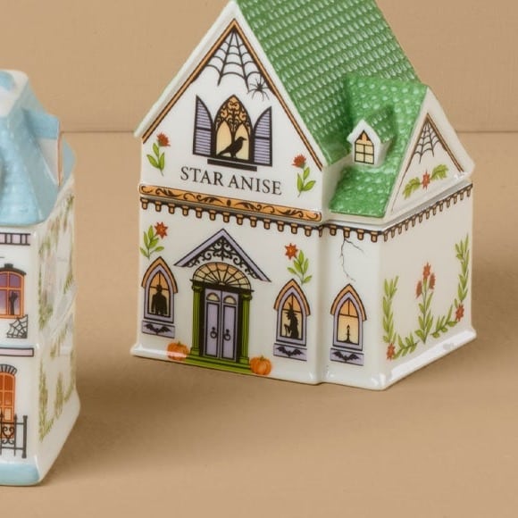 Close-up of the Lenox Spice Village Halloween star anise jar with a spiderweb gable and witch silhouette