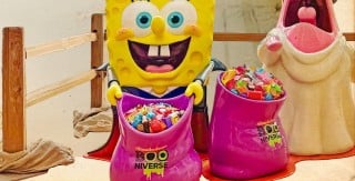 A SpongeBob SquarePants vampire figure holds a pink Nickelodeon Booniverse bowl full of candy beside a Patrick Star ghost figure