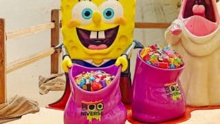 A SpongeBob SquarePants vampire figure holds a pink Nickelodeon Booniverse bowl full of candy beside a Patrick Star ghost figure