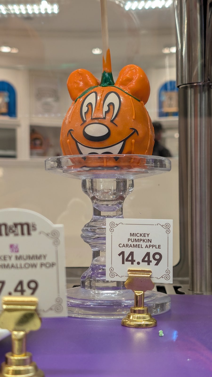 A Mickey Pumpkin Caramel Apple priced at $14.49 at Magic Kingdom