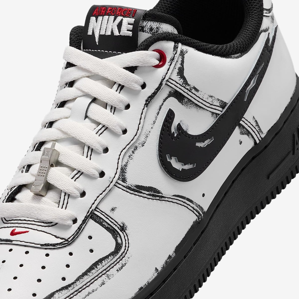 Close-up of the white Air Force 1 tongue tag reading NIKE in jagged Scream-style letters under a red AIR FORCE 1