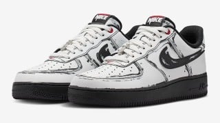 A pair of white Nike Air Force 1 sneakers with black sketched outlines, slashed black Swooshes, and black soles