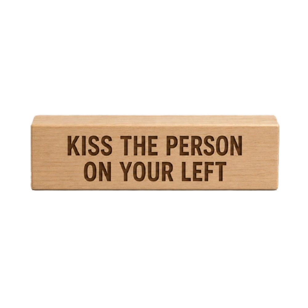 The wooden block from the Obsession Bear costume set, stamped Kiss the person on your left