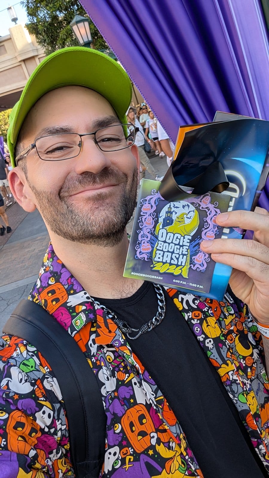 Philip Hernandez holding the 2026 event guide at Oogie Boogie Bash opening night