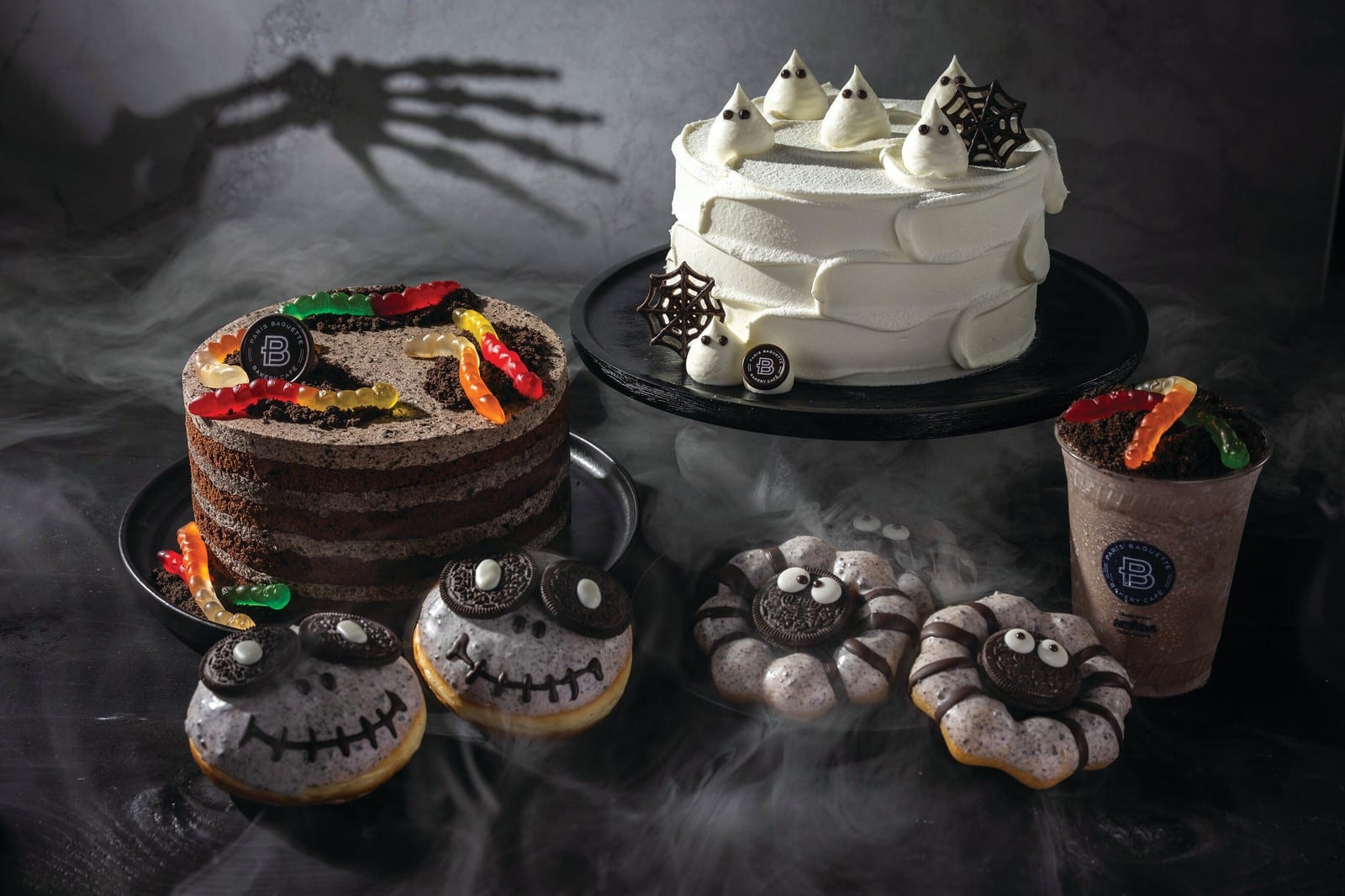 Paris Baguette's Halloween lineup: a dirt-and-worms chocolate cake with gummy worms, a white ghost cake, a dirt-and-worms frappe, Halloween Scream Donuts with cookie eyes, and Spider Mochi Donuts