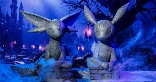 Pokemon Center Halloween stone-look Espeon and Umbreon yard statues in a foggy graveyard scene