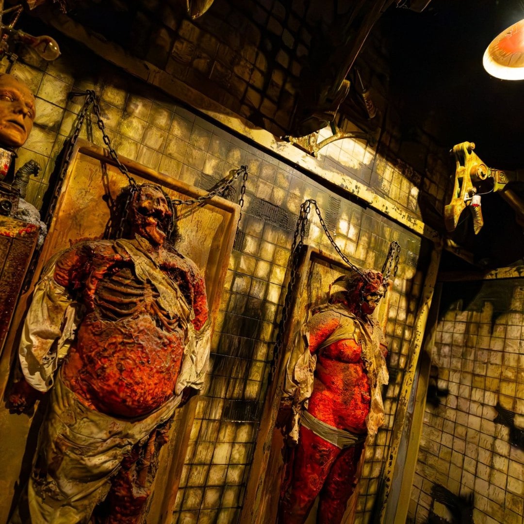 Rotting bodies chained to tiled walls inside a Pure Terror Scream Park haunted house