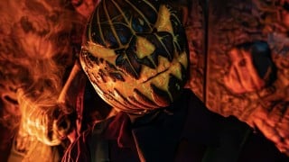A pumpkin-headed figure lit by orange firelight at Pure Terror Scream Park