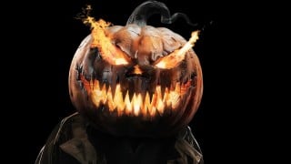 A figure with a carved, flaming jack-o'-lantern for a head and a dark coat, against a black background