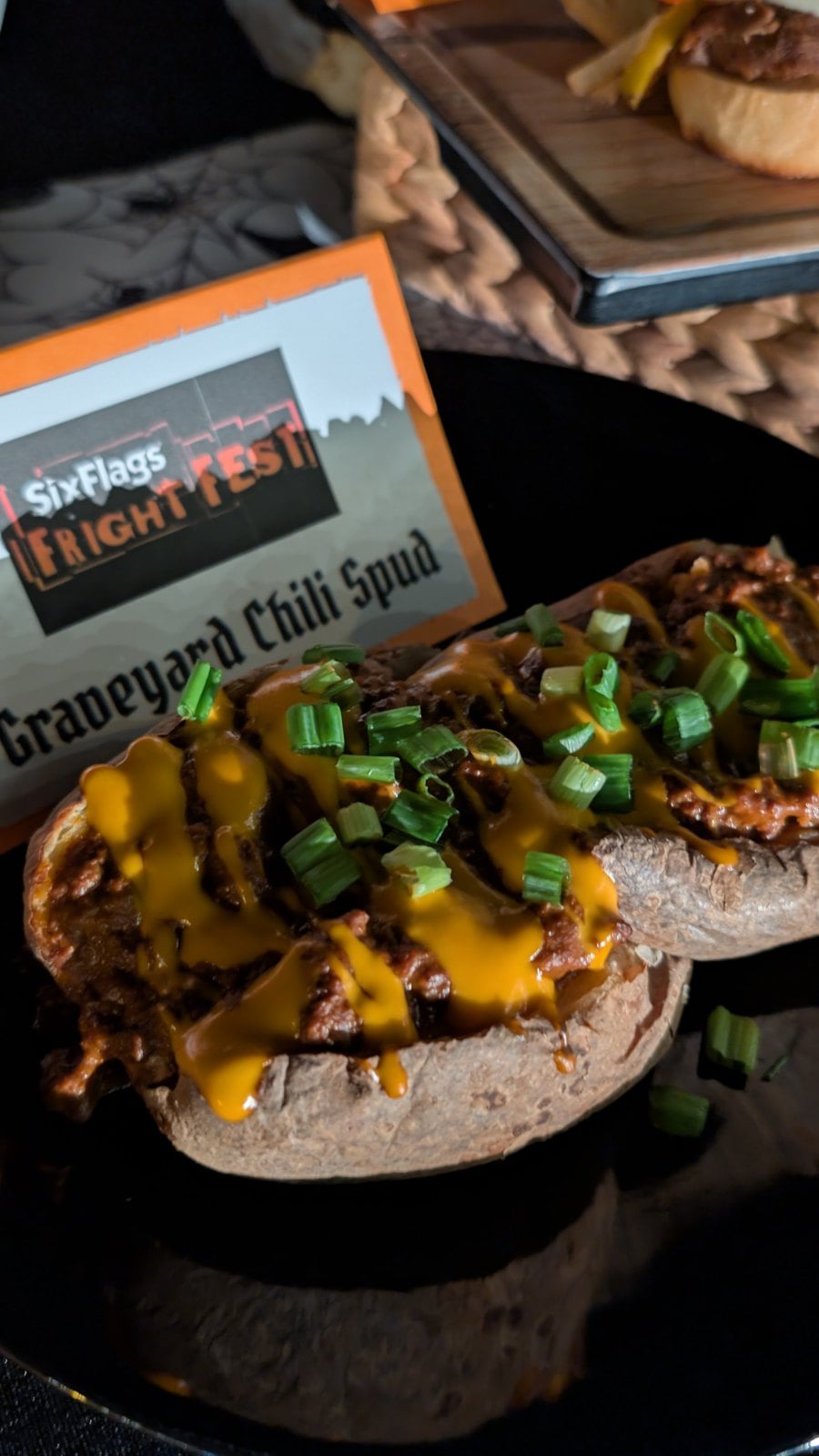 Graveyard Chili Spud, a baked potato with beef chili, cheese sauce, and green onions